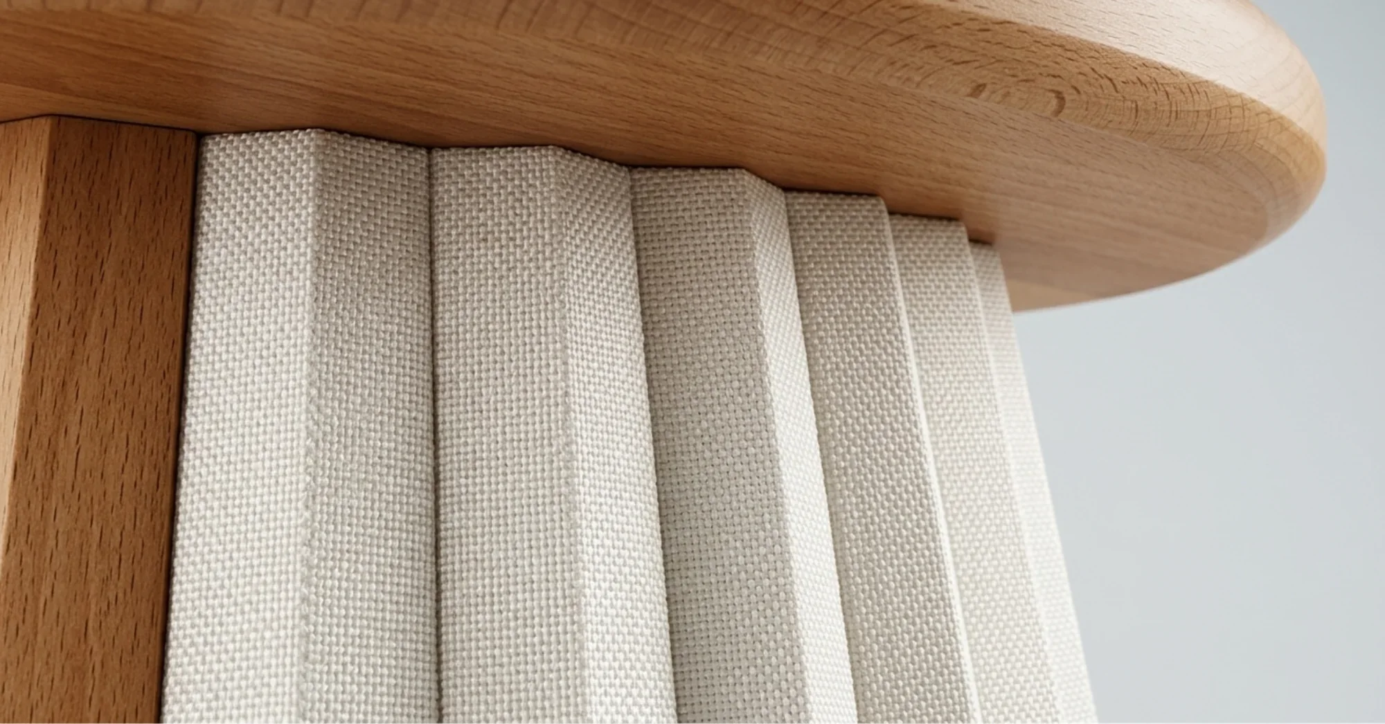 Close-up of the Folssé stool: a wooden seat over a pleated textile shell